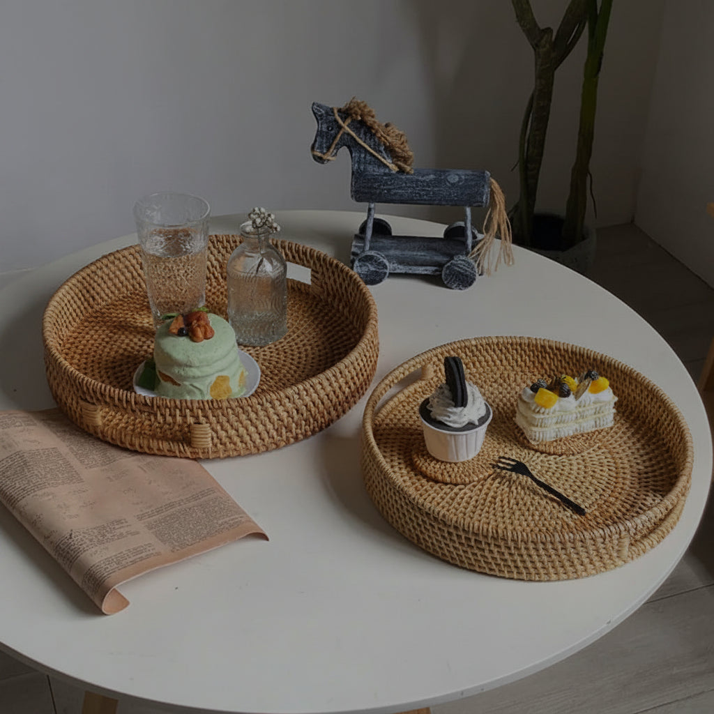 Duas bandejas de rattan em tamanhos diferentes sobre mesa branca com cupcakes e decoração