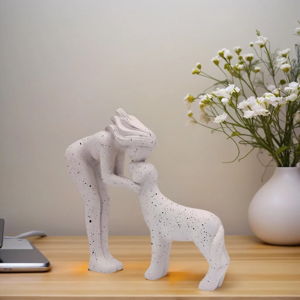 Escultura decorativa em resina representando uma menina carinhosa ao lado de um cachorro.