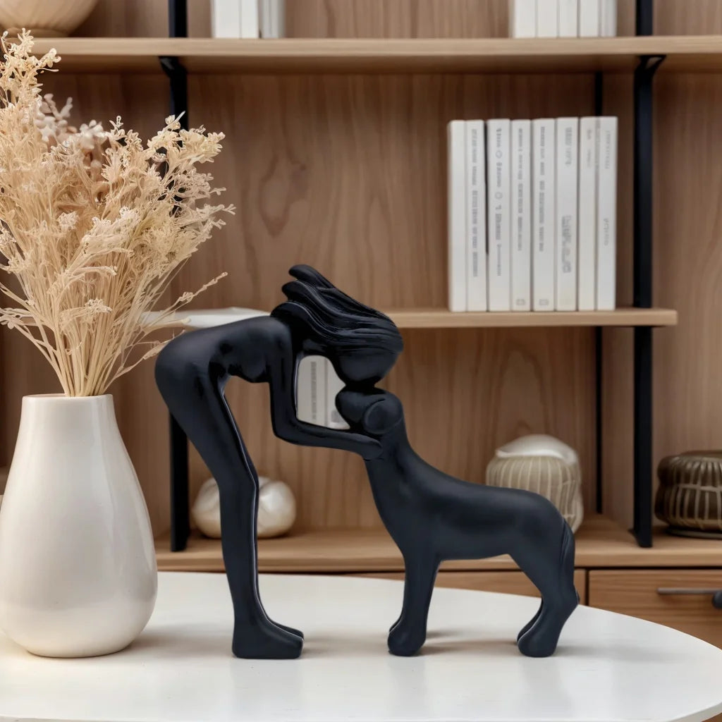 Escultura decorativa em resina representando uma menina carinhosa ao lado de um cachorro.