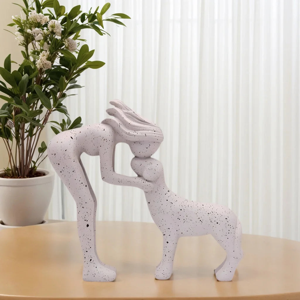 Escultura decorativa em resina representando uma menina carinhosa ao lado de um cachorro.