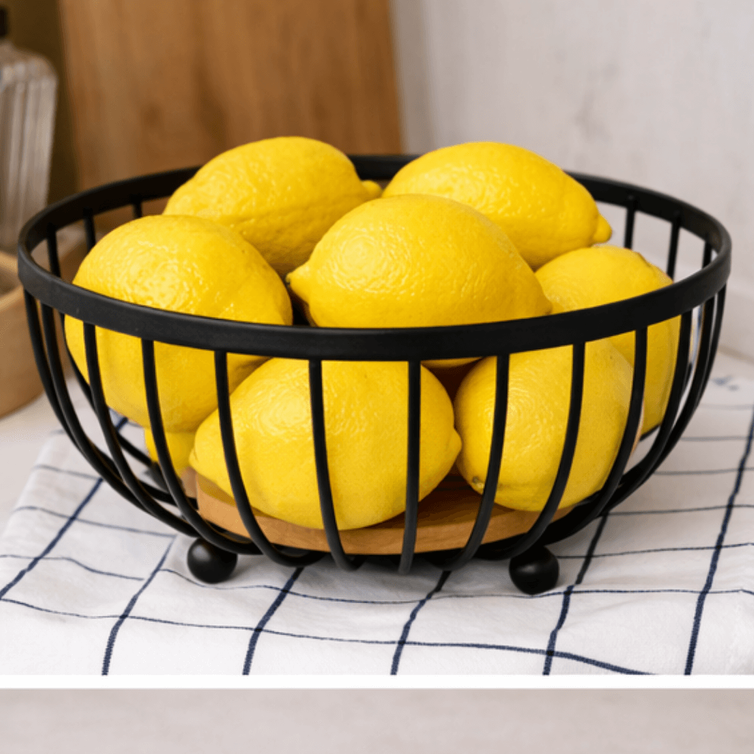 Fruteira de arame preto cheia de limões amarelos sobre pano xadrez – fruteira decorativa cozinha