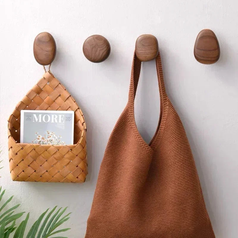 Gancho de madeira maciça com design moderno e formato de seixo. Instalação sem furos, ideal para roupas, toalhas e organização prática.