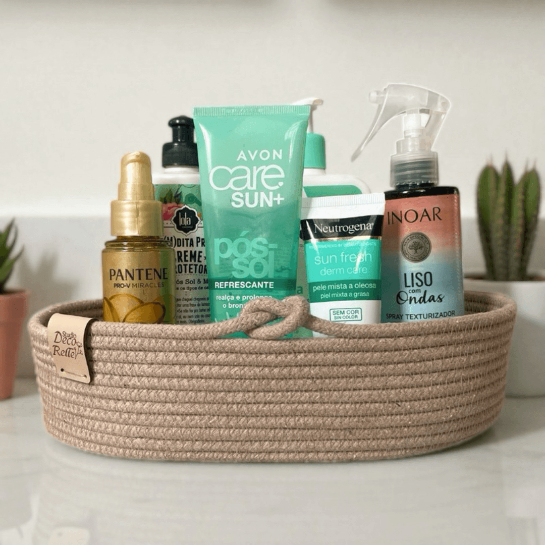 Organizador oval de corda de algodão bege com produtos de beleza e skincare sobre bancada clara