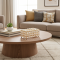Porta-lenços luxuoso em cristal e metal dourado sobre mesa de centro redonda em sala de estar