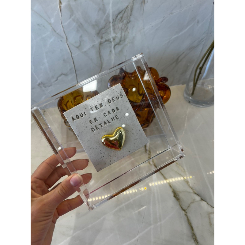 Quadro de Acrílico com placa de cerâmica “ Aqui tem Deus em cada detalhe ”. o modelo de coração pode variar